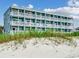 Multi-story building directly on the beach with multiple balconies at 116 South Waccamaw Dr. # 204, Garden City Beach, SC 29576