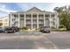 Two-story condo building with ample parking and tree-lined surroundings at 5810 Longwood Dr. # 14-304, Murrells Inlet, SC 29576