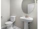 Elegant powder room with pedestal sink and oval mirror at 288 Starlit Way, Myrtle Beach, SC 29579