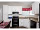 Modern kitchen with white cabinets, black appliances, and granite countertops at 1517 Schooner Ct., Garden City Beach, SC 29576
