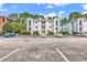 Three-story building with parking lot and landscaping at 4255 Villas Dr. # 201, Little River, SC 29566