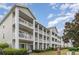 Multi-unit building with light-colored siding, balconies, and landscaping at 1009 World Tour Blvd. # 301, Myrtle Beach, SC 29579