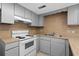 Bright kitchen boasts gray cabinets, wood-look countertops, and white appliances at 500 Deer Creek Rd. # D, Surfside Beach, SC 29575