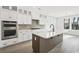 Modern kitchen featuring white cabinets, dark wood island, stainless steel appliances, and large windows at 512 9Th Ave. S, North Myrtle Beach, SC 29582