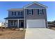 Two-story house with gray and blue siding, white garage door, and landscaping at 831 Buttonwood Dr., Conway, SC 29527