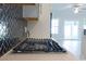 Modern gas cooktop in a kitchen with white cabinets and a herringbone backsplash at Tbb1 Shady Grove Rd., Conway, SC 29527