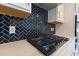 Close-up view of a gas cooktop with dark herringbone tile backsplash at Tbb1 Shady Grove Rd., Conway, SC 29527