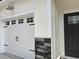 White garage door with black hardware and stone accents at 3125 Tiger Tail Rd., Conway, SC 29526