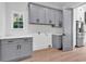 Bright laundry room with gray cabinets and marble countertops at 204 Bouquets Green Way, Myrtle Beach, SC 29579