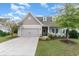 House exterior with a two-car garage and well-landscaped yard at 794 Thistle Trail, Calabash, NC 28467