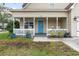 Front porch with rocking chairs, planters, and blue door at 1356 Tranquility Ln., Myrtle Beach, SC 29577