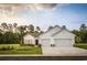 White two-story house with three-car garage and landscaping at 6088 Zoe Way, Myrtle Beach, SC 29588