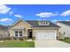 Tan house with white garage door and landscaping at 5042 Selene Ct., Myrtle Beach, SC 29588