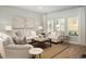 Bright living room features a comfy sofa and chairs, large windows, and hardwood floors at 5054 Selene Ct., Myrtle Beach, SC 29588