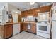Kitchen with wood cabinets, white appliances, and tiled floor at 5905 S Kings Highway # 219-B, Myrtle Beach, SC 29575