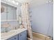 Small bathroom with tub, seashell shower curtain, and blue vanity at 6001-1092 S Kings Hwy., Myrtle Beach, SC 29575
