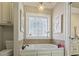 Relaxing bathroom with a soaking tub, tile flooring, and a chandelier at 6001 S Kings Hwy., Myrtle Beach, SC 29575