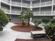 A serene courtyard with tropical plants and a bench offers a relaxing community space at 10166 Beach Dr. # 5306, Calabash, NC 28467