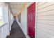 Exterior hallway with carpet flooring and burgundy front door at 3681 Claypond Rd. # 3107, Myrtle Beach, SC 29579