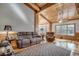 Spacious living room featuring hardwood floors, wood beams, and large windows at 7018 Cox Lake Ct., Mullins, SC 29574