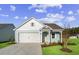 Charming light blue house with white accents, a two-car garage, and a landscaped lawn at 3022 Deerberry Place, Longs, SC 29568