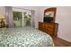 Main bedroom with a king-size bed, dresser, and private balcony overlooking the tennis court at 601 N Hillside Dr. # 2123, North Myrtle Beach, SC 29582