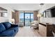 Oceanfront living room with balcony access, comfy seating, and a large TV at 1501 Ocean Blvd. S # 839, Myrtle Beach, SC 29577