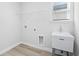 Bright laundry room with utility sink, shelving, and vinyl flooring at 623 Blackthorne Circle Nw, Calabash, NC 28467