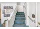 Staircase with teal carpet runner and white railings leading to the upper level at 1000 Strand Ave., North Myrtle Beach, SC 29582