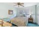 Bright bedroom with a floral-patterned bed, ceiling fan, and ample natural light at 1000 Strand Ave., North Myrtle Beach, SC 29582