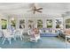 Sunroom features a sofa, rocking chair, and dining area with ample natural light at 1000 Strand Ave., North Myrtle Beach, SC 29582