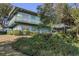 Two-story house with a balcony, surrounded by lush greenery at 1000 Strand Ave., North Myrtle Beach, SC 29582
