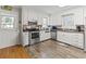 White kitchen cabinets, stainless steel appliances, and hardwood floors at 1210 John St., Mullins, SC 29574