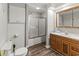 Clean bathroom, featuring a shower/tub combo, wood vanity, and updated flooring at 1210 John St., Mullins, SC 29574