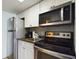 Small kitchen with stainless steel appliances and white cabinets at 6900 N Ocean Blvd. # 410, Myrtle Beach, SC 29572