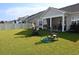 Large backyard with grassy area, and rocking chairs at 2013 Great Blue Heron Dr., Little River, SC 29566
