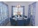Bright dining area with a glass-top table and blue upholstered chairs at 2013 Great Blue Heron Dr., Little River, SC 29566