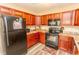 Modern kitchen with dark wood cabinets, black appliances, and granite countertops at 333 Carolina Springs Ct., Conway, SC 29527