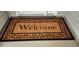 A coir welcome mat with a black border and the word 
