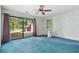 Bright bedroom with blue carpet, ceiling fan, and sliding glass doors at 19 South Gate Rd., Myrtle Beach, SC 29572
