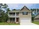 Two-story home with beige siding, red door, and a white garage door at 1889 Brook Park Pl., Conway, SC 29526
