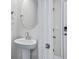 Stylish bathroom with a pedestal sink and round mirror at 3539 Rayner Cove Ct., Little River, SC 29566