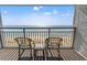 Oceanfront balcony with chairs and table, offering stunning ocean views at 7100 N Ocean Blvd. # 913, Myrtle Beach, SC 29572