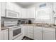White kitchen with stove, microwave, and corner sink at 6001 - 1870 S Kings Hwy., Myrtle Beach, SC 29575