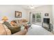 Living room with beige couch, glass table, and access to a balcony at 1100 Commons Blvd. # 107, Myrtle Beach, SC 29572