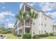 Tan multi-story condo building with screened balconies and palm trees at 1100 Commons Blvd. # 107, Myrtle Beach, SC 29572