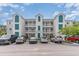 Three-story condo building with teal accents and ample parking at 1100 Commons Blvd. # 107, Myrtle Beach, SC 29572