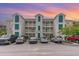 Condo building exterior with parking lot and cars at 1100 Commons Blvd. # 107, Myrtle Beach, SC 29572