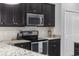 Modern kitchen with dark cabinets and stainless steel appliances at 160 Freeboard Ln. # 802, Carolina Shores, NC 28467
