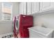 Bright laundry room with white cabinets and red washer and dryer at 505 Quincy Hall Dr., Myrtle Beach, SC 29579